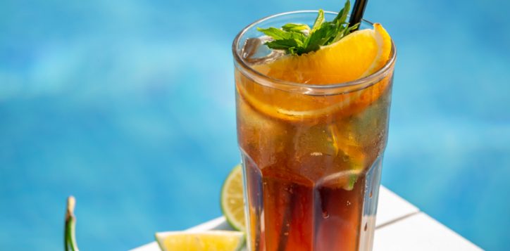 red-cocktail-with-lemon-orange-slices-hreen-herbs-by-pool-1-2